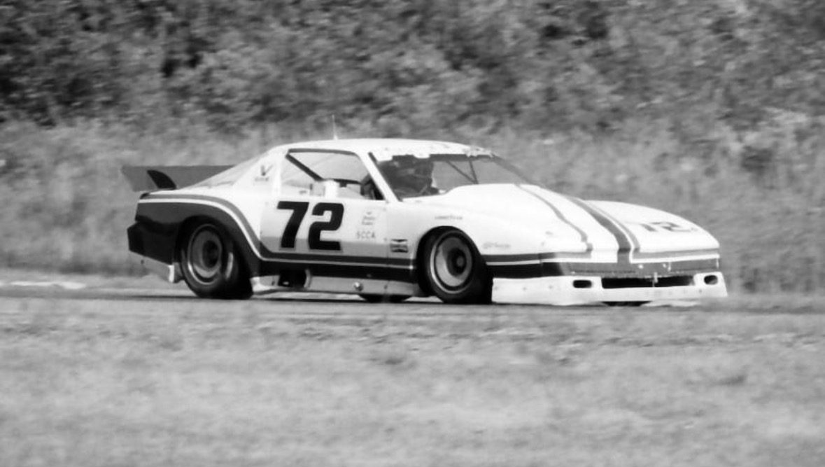 Bruce Jenner's striped 1982 Pontiac Firebird #72 at speed, SCCA decal on the door