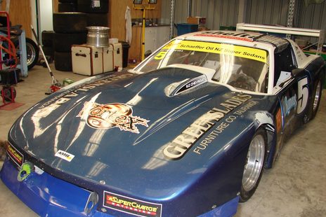 The #5 Camaro head-on in the workshop: Greenslades Furniture Co. Tauranga and Vortex on the bonnet, SuperCharge Batteries on the splitter