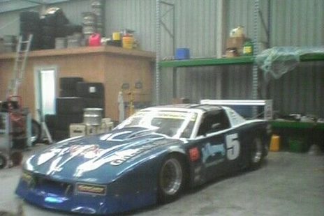 The blue #5 Camaro parked in a large workshop