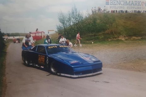 The blue Pontiac being pushed past the Benchmark Building Supplies banner at Manfeild
