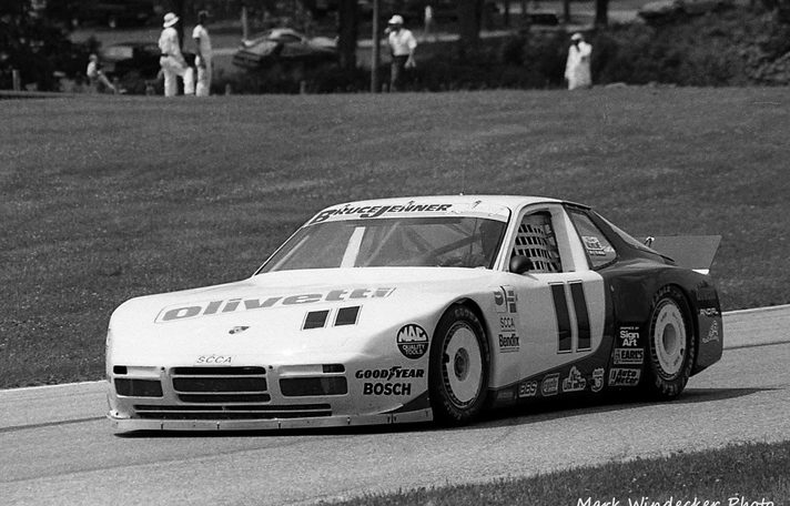 The #11 Porsche 944 on track, Olivetti on the bonnet