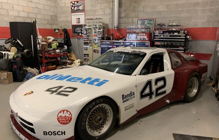 The #42 Porsche 944 in a workshop with Olivetti and 42 on the bonnet and HSR decals
