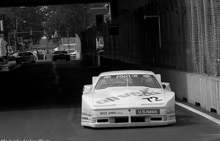 The #72 U.S. News Pontiac in black and white under a bridge on a 1988 street circuit